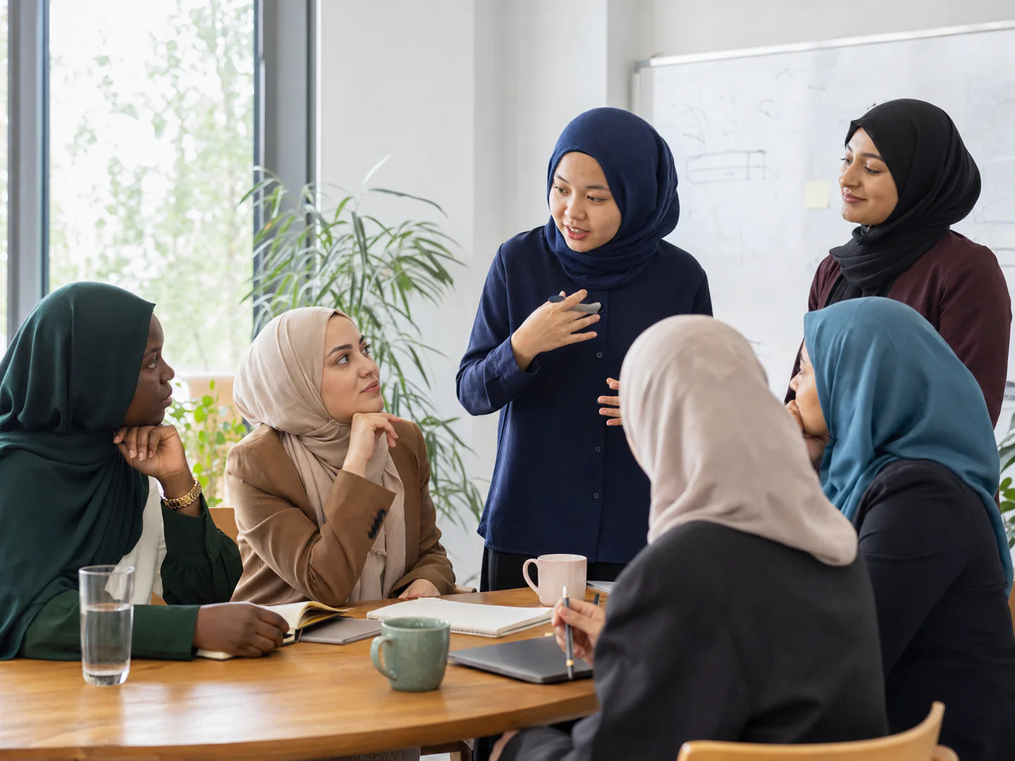 Muslim women in hijab taking part in a small professional mentorship discussion